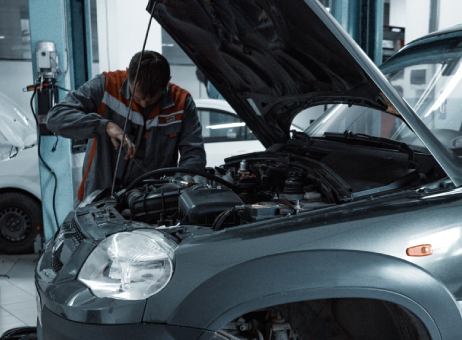 Mechanic performing checks on a car under the bonnet